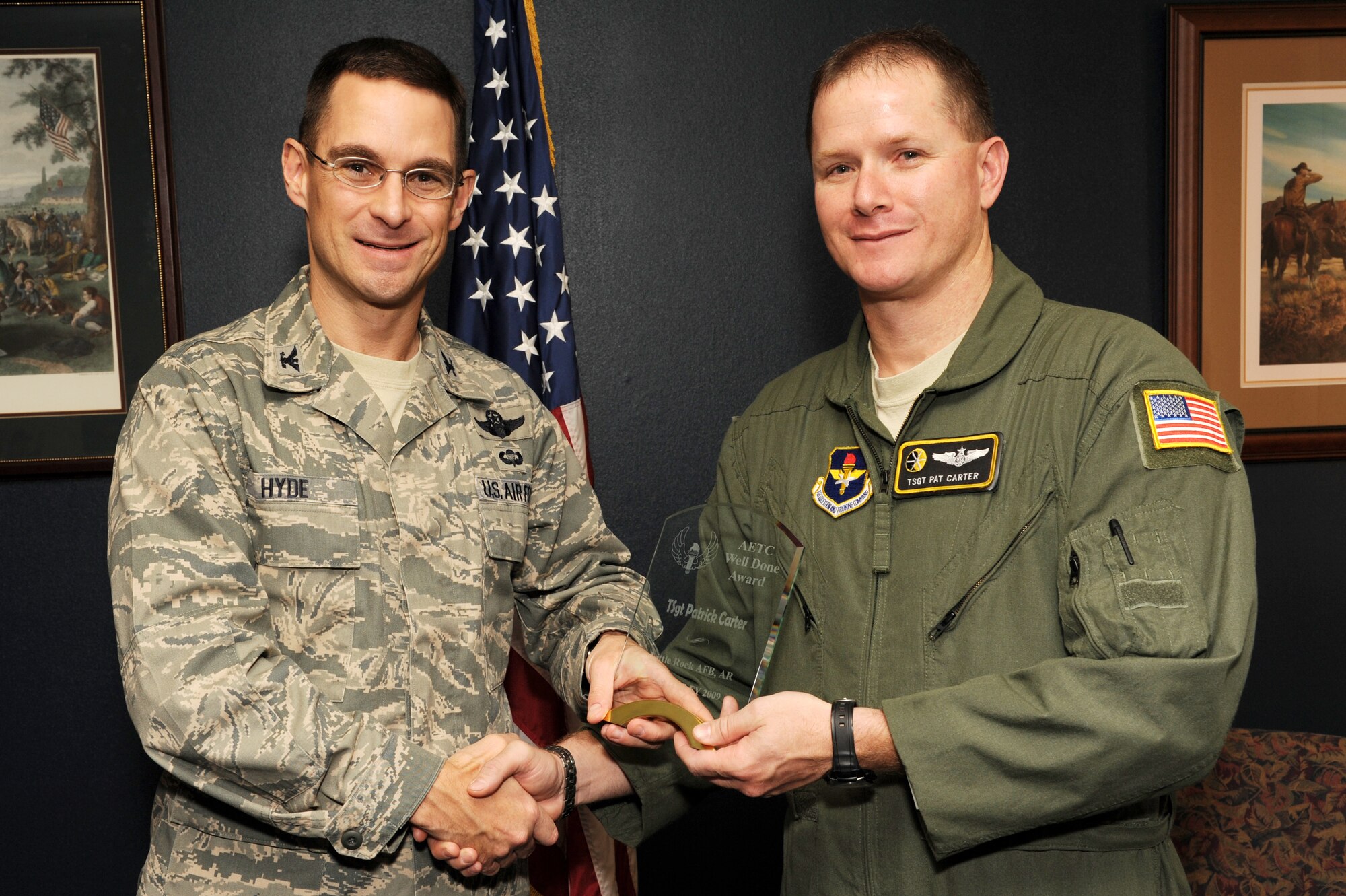 Col. C. K. Hyde, 314th Airlift Wing commander, presents the Air Education and Training Command Well Done Award to Tech. Sgt. Patrick Carter, 48th Airlift Squadron NCO-in-charge of student training, on base Nov. 4. Sergeant Carter's judgment, expert analysis and innovative communicative techniques, averted a potentially catastrophic scenario, leading to the safe return of four crew members and a $60 million aircraft. (US Air Force photo by Senior Airman Jim Araos)