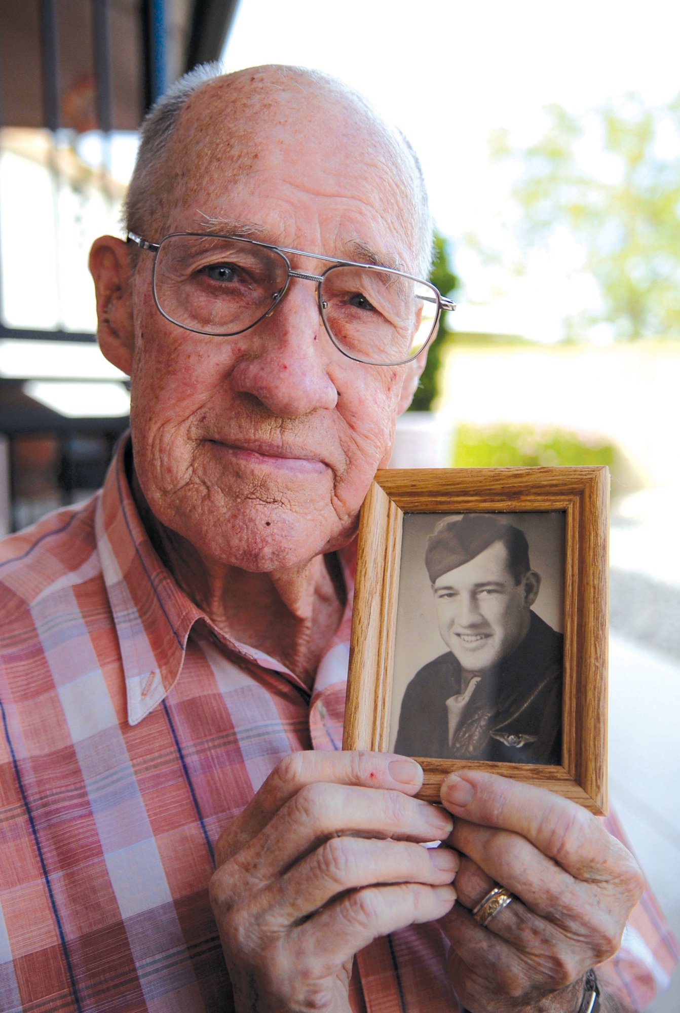Stan Angleton, a World War II veteran and prisoner of war, poses with a photo showing him as a young engineer in the Army Air Corps on Oct. 30, 2009. Mr. Angleton now resides in Sun City West, Ariz. (U.S. Air Force Photo/Tech. Sgt. Jeffrey Wolfe)