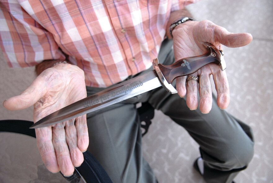 Stan Angleton, a World War II veteran and prisoner of war, holds an SS knife  he traded for in Europe after WWII ended. Mr. Angleton was held as a POW for 15-and-a-half months before he and five other prisoners escaped their German captors. He currently resides in Sun City, Ariz. (U.S. Air Force photo/Tech. Sgt. Jeffrey Wolfe)
