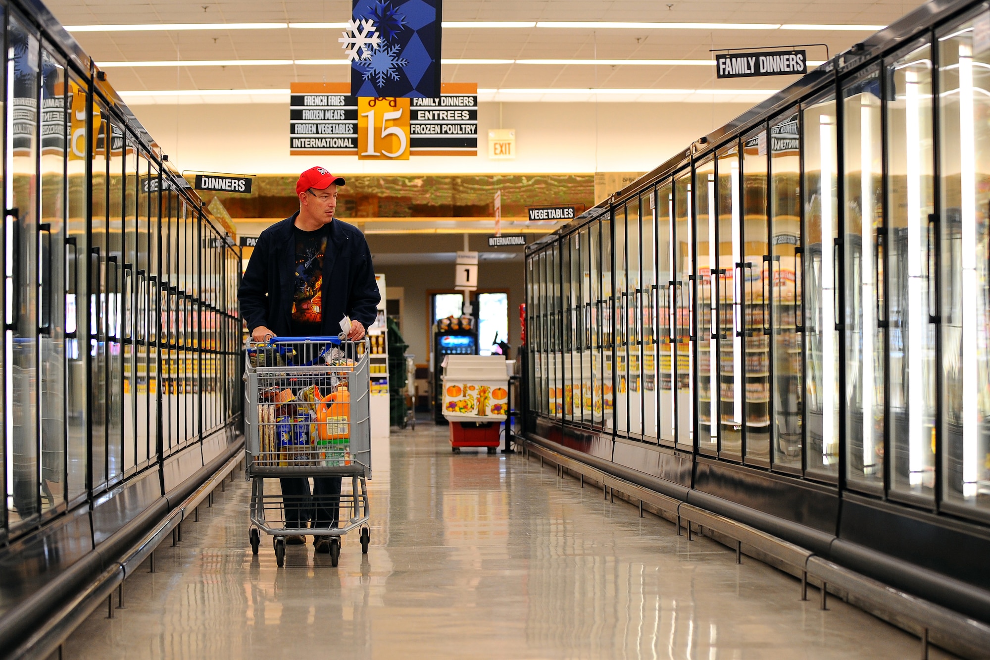 OFFUTT AIR FORCE BASE, Neb. - Joseph Milos, a retired Air Force Reservists, strolls through the frozen food aisle of the Offutt Commissary with coupons in hand Nov. 4. Utilizing coupons is one way shoppers can save money. U.S. Air Force photo by Josh Plueger