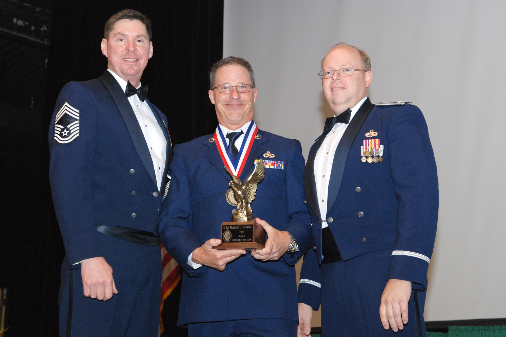 Staff Sgt. Bradley Beams, B-52H crewchief, 917th Aircraft Maintenance Squadron, Barksdale Air Force Base, La., receives the Junior Golden Gator Award during the Gatorfest Banquet, November 7, 2009, for his outstanding accomplishments during Giant Sword II/Proud Shield II Bomb & Load Competition, which is a bomber competition demonstrating a squadrons ability to drop accurate bombs and regenerate aircraft. Gatorfest is an annual awards banquet held by the 917th Wing to recognize individuals who made the greatest contribution within their career field to the 917th maintenance community. The award was presented by Lt. Col. Jeffrey Mullen, commander, 917th Maintenance Group, and Chief Master Sgt. Mark LaFayette, First Sergeant, 917th Maintenance Group. (US Air Force photo/Master Sgt. Greg Steele) 