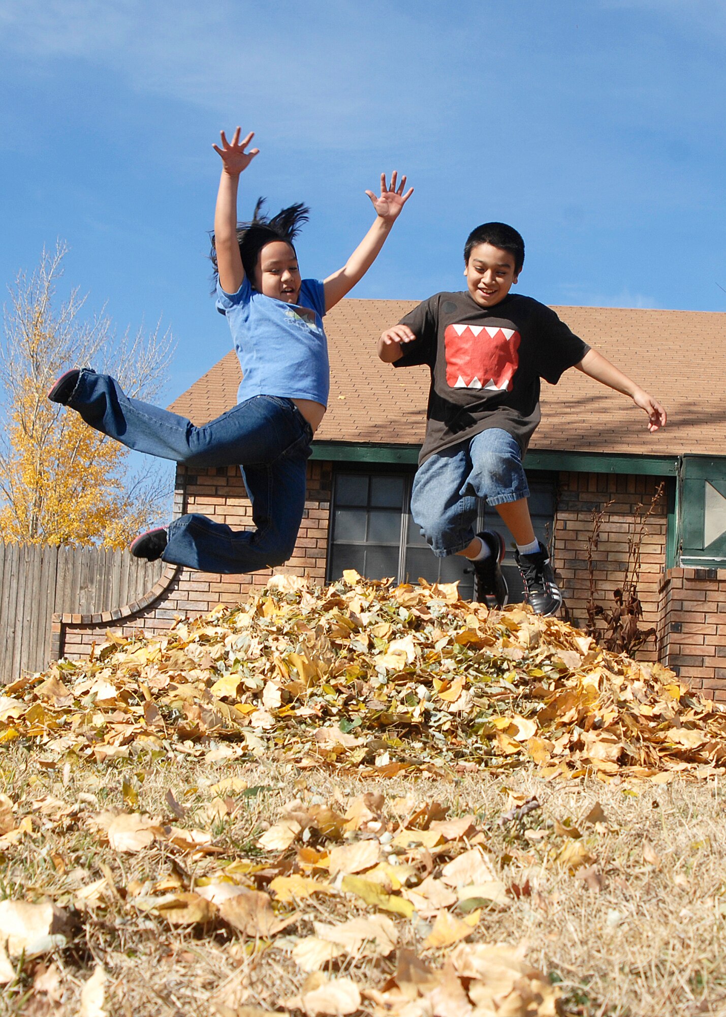 CANNON AIR FORCE BASE, N.M. -- Valerie and Anthony Mejia give in to temptation after raking leaves Nov. 9. They are the children of Tech. Sgt. Luis Mejia, 27th Special Operations Component Maintenance Squadron, and his wife Alejandra. (U.S. Air Force photo by Greg Allen)