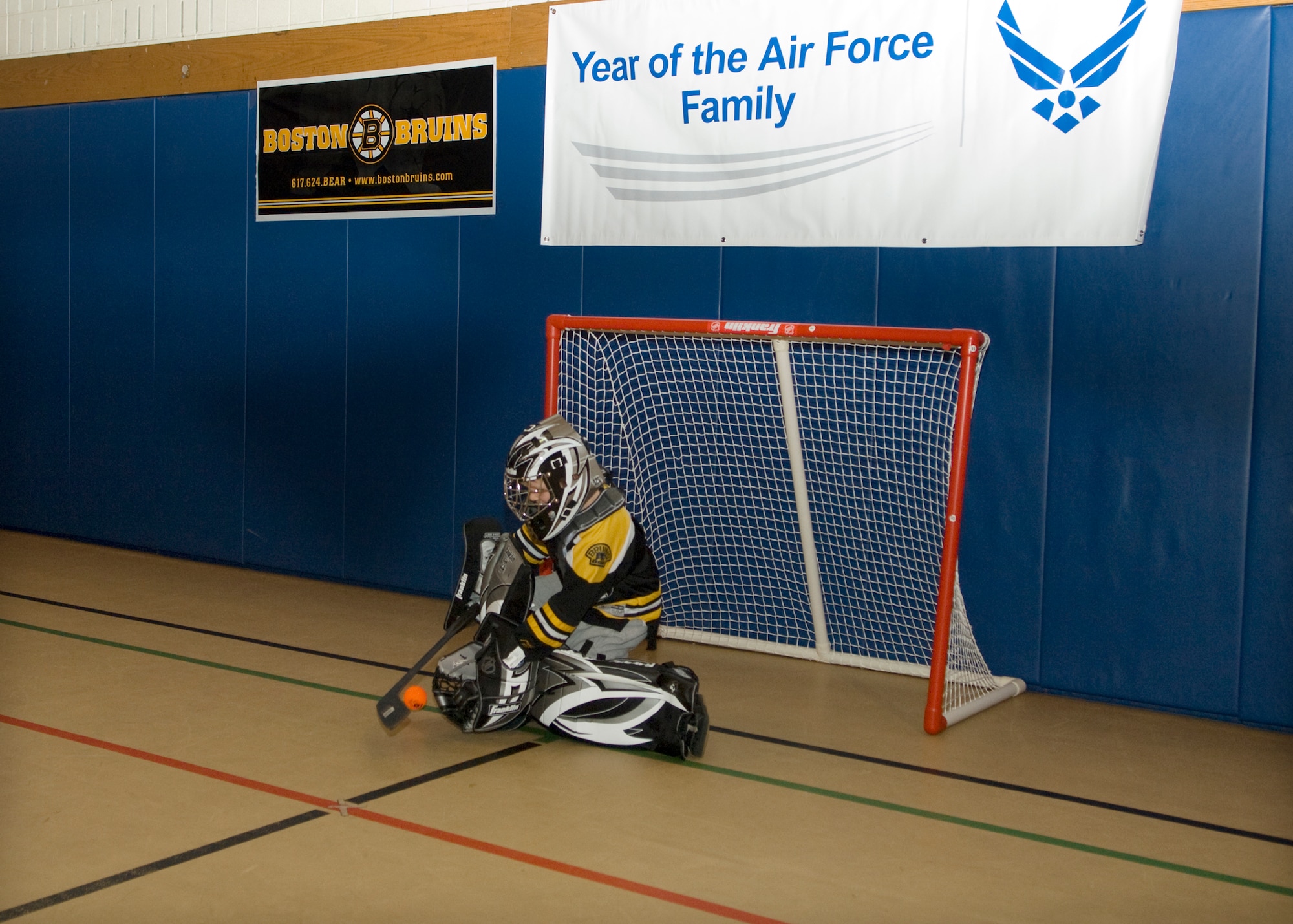HANSCOM AIR FORCE BASE, Mass. – Justin Netemeyer blocks a shot on goal during an Air Force Family Week street hockey event at the Hanscom Youth Center Nov. 4, sponsored by the Boston Bruins and Operation Homefront. Former Boston Bruins player Tommy Songin, along with other Bruins staff, led Hanscom children through a number of street hockey drills focusing on the fundamentals of play. (U.S. Air Force photo by Walter Santos)