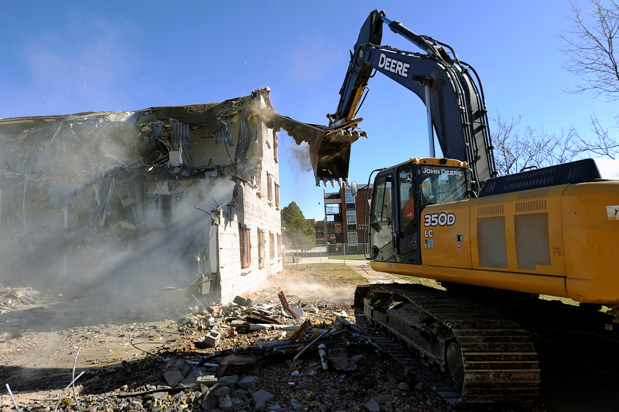 Demolition crews take down a three-story dormitory Nov. 4, at the corner of Otis Street and Stewart Avenue on Peterson Air Force Base. The demolition is part of the Air Force "20/20 by 2020" program, which aims to reduce real property square footage by 20 percent and reduce building maintenance costs by 20 percent by the year 2020. The old dormitory has been vacant for several years because it did not meet current building standards. About 45 percent of the building materials will be recycled. (Air Force photo by Larry Hulst)