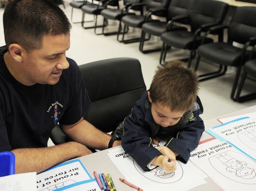 1st Lt. Paul Padilla colors pictures with his son, August, in the arts section at the Airman and Family Readiness Center open house for Air Force Family Week Nov. 4, 2009, at Ramstein Air Base, Germany. Lieutenant Padilla is an 86th Air Evacuation Squadron flight nurse. (U.S. Air Force photo/Airman 1st Class Caleb Pierce)