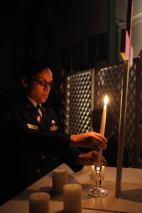 LANGLEY AIR FORCE BASE, Va.-- Staff Sgt. Diana Sturdivant, Air Combat Command Formal Training noncommissioned officer in charge, lights a candle honoring fallen Air Force Service members, during an early Veterans Day celebration hosted by the Niners Senior Citizens of Chesapeake Nov. 5.  Military members from each branch of service lit candles to honor their branch’s fallen, and exchanged roses with veterans during the ceremony to honor past, present and fallen military members.  (U.S. Air Force photo/Staff Sgt. Christina M. Styer)