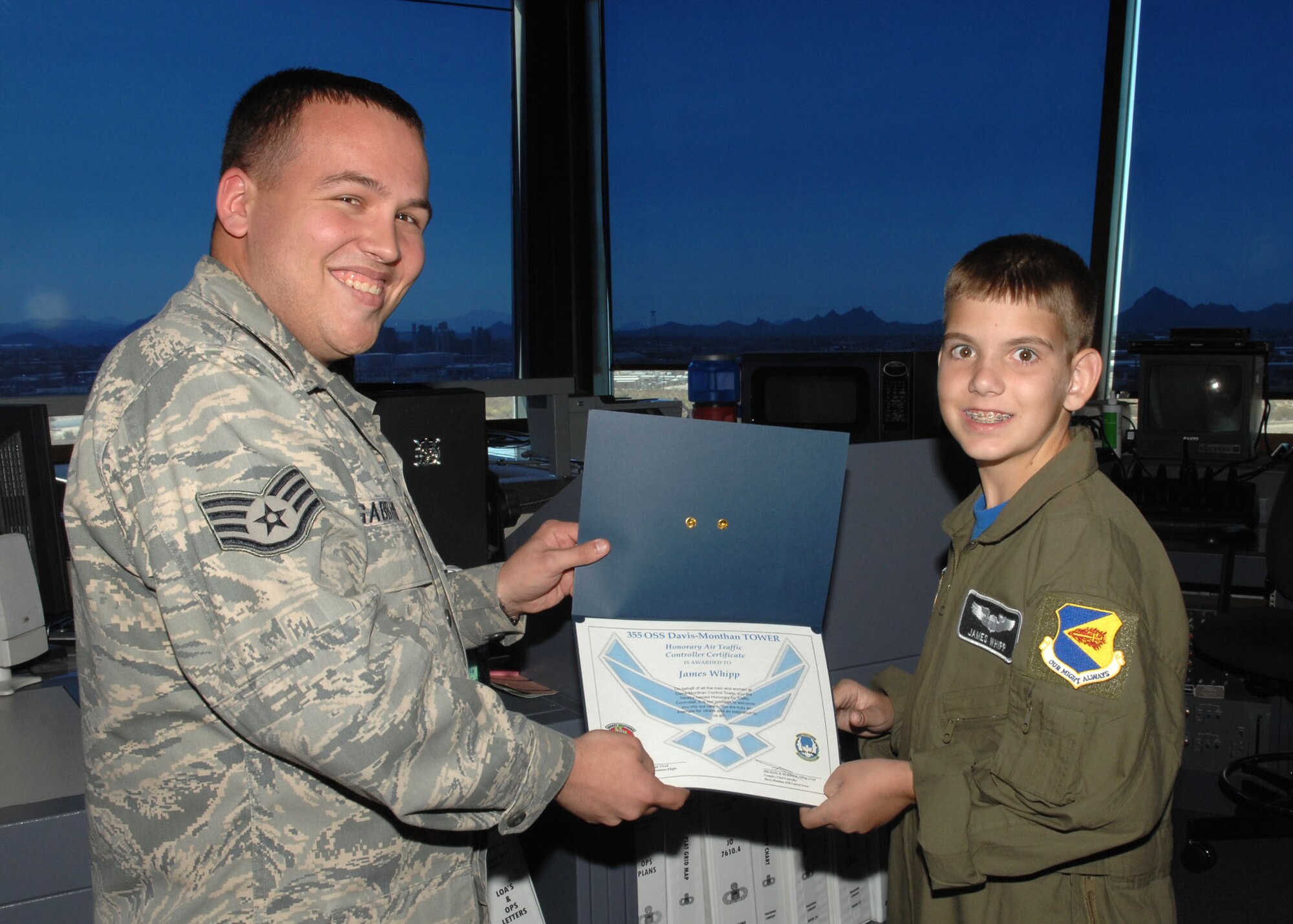 Staff Sgt. Joshua Gabbard, 355th Operations Support Squadron, presents Pilot for a Day participant James Whipp, 12 with an Honorary Air Traffic Controller Certificate and occupational badge. James was selected to be a part of this month's Pilot for a Day program which benefits children of the local community who have catastrophic illnesses. (U.S. Air Force photo/Airman Jerilyn Quintanilla)