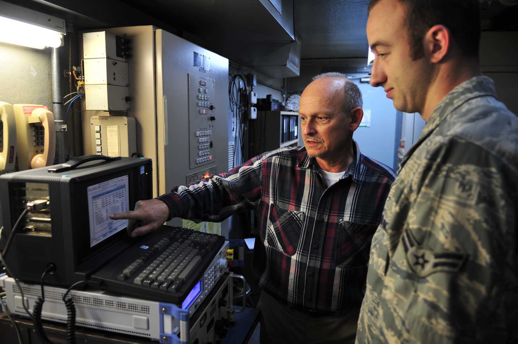 Wayne Moriniti and Airman 1st Class Joshua Dishner examine a recording process for Bexr radar equipment at Seymour Johnson Air Force Base, N.C., Nov. 5, 2009. Bexr radar equipment communicates with the aircraft by sending an identify friend or foe signal to the pilot or weapons system officer who signals back with a four digit alpha-numeric code. Mr. Moriniti and Airman Dishner are from the 4th Communications Squadron radar maintenance work center. Airman Dishner is originally from Bristol, Tenn. (U.S. Air Force photo/Airman 1st Class Rae Perry)