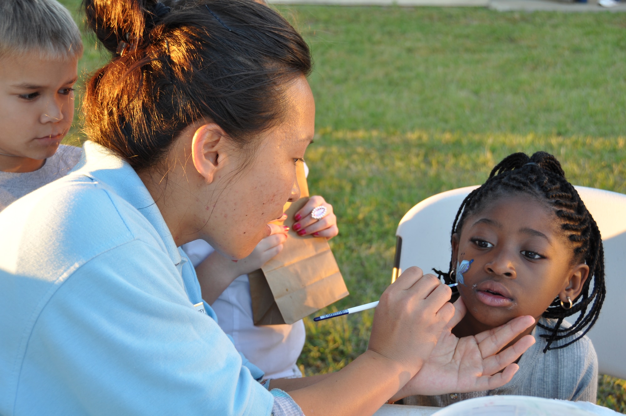 EGLIN AIR FORCE BASE, Fla. -- Nevaeh Shatel-Wallace, 6, gets a blue butterfly painted on her cheek comlpiments of volunteer artist Bon Zegouros, Eglin School Age Program assistant, during the center's Fall Fest Nov. 6. Partcipants were treated to cotton candy, face painting, pie throwing and other activities with their parents during the Air Force Family Week event. (U.S. Air Force photo/Chrissy Cuttita)