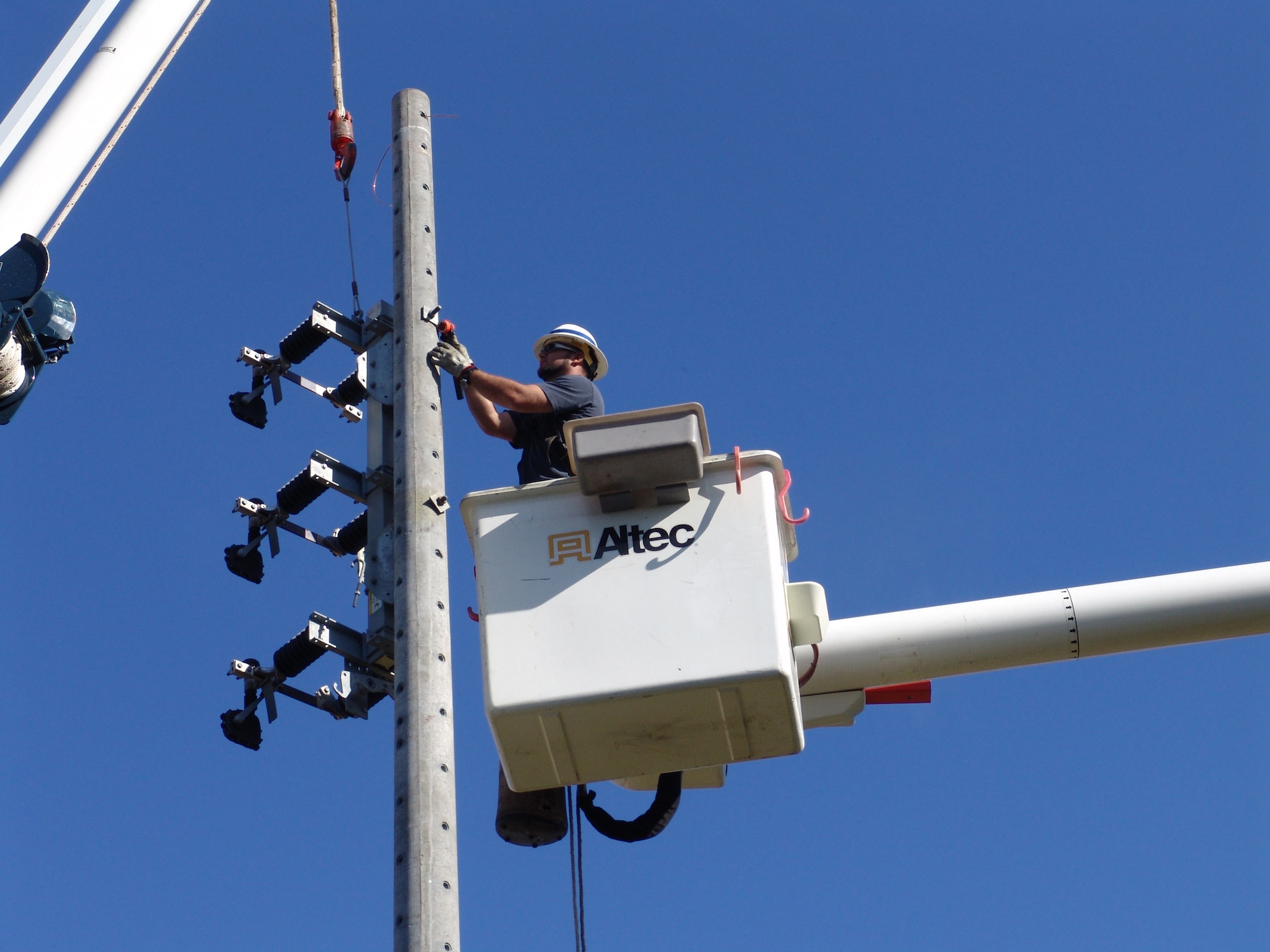 Dusty Dees hangs a three-phase air break switch used to tie circuits together on a power pole. It is one of many duties that falls under the 96th Civil Engineer Squadron's exterior electrical shop. (USAF photo/Lois Walsh)
                             