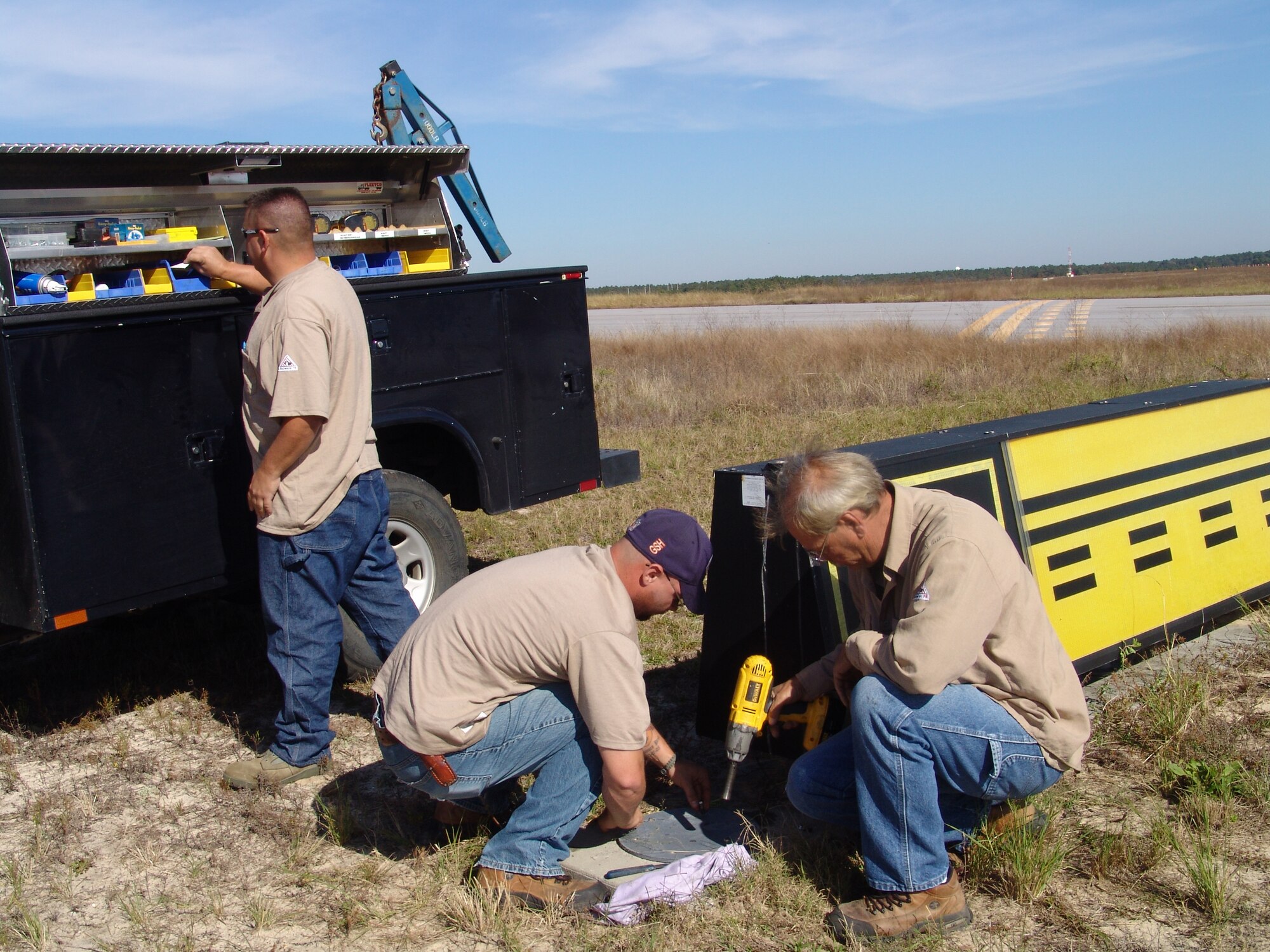 Adam Nixon and Frank McCallion close the cover on a high voltage transformer on the airfield.  It is one of many duties that falls under the 96th Civil Engineer Squadron's exterior electrical shop. (USAF photo/Lois Walsh)