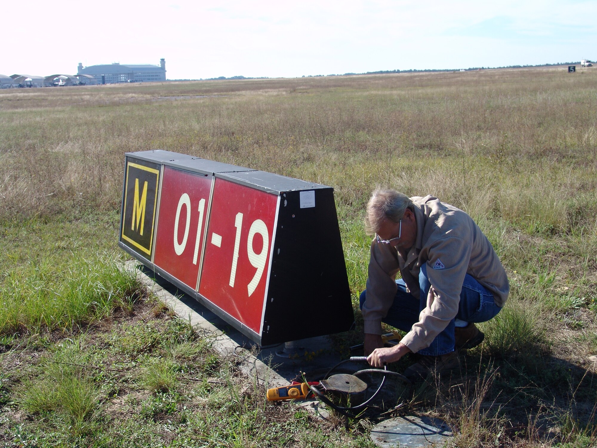Frank McCallion checks the connection at a distance marker on the runway. It is one of many duties that falls under the 96th Civil Engineer Squadron's exterior electrical shop. (USAF photo/Lois Walsh)