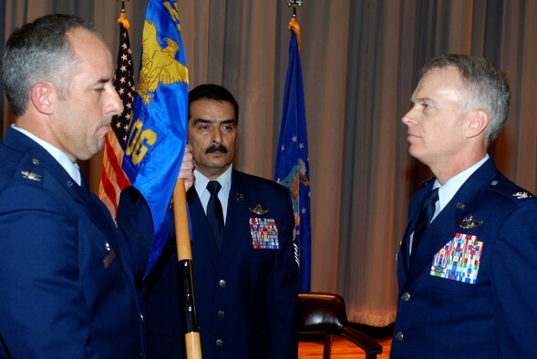 PATRICK AIR FORCE BASE, Fla. - Colonel Steve W. Kirkpatrick hands over the flag of the 920th Rescue Wing Operations Group to their new commander Colonel Christopher P. Hannon at a change of command ceremony. The Operations Group is responsible for the overall combat training and readiness of nearly 300 aircrew, pararescue specialists and support command. (U.S. Air Force Photo/Master Sgt. Bryan Ripple) 