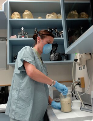 Dental technician Staff Sgt. Dinah Laduke, Maxillofacial, 59th Dental Training Squadron, NCO-in-charge Prosthodontics Element, prepares plaster for making molds of Marine Sgt. Wade Knight's ears at MacKown Dental Clinic, Lackland Air Force Base, Texas, Oct. 27. Sergeant Knight's ears were used as models to make fellow Marine and wounded warrior Capt. Ryan Voltin a set of prosthetic ears. Both Captain Voltin and Sergeant Knight were injured in Iraq and met at the Warrior Transition Program, Brooke Army Medical Center, Fort Sam Houston, Texas. (U.S. Air Force photo/Master Sgt. Kimberly A. Yearyean-Siers)