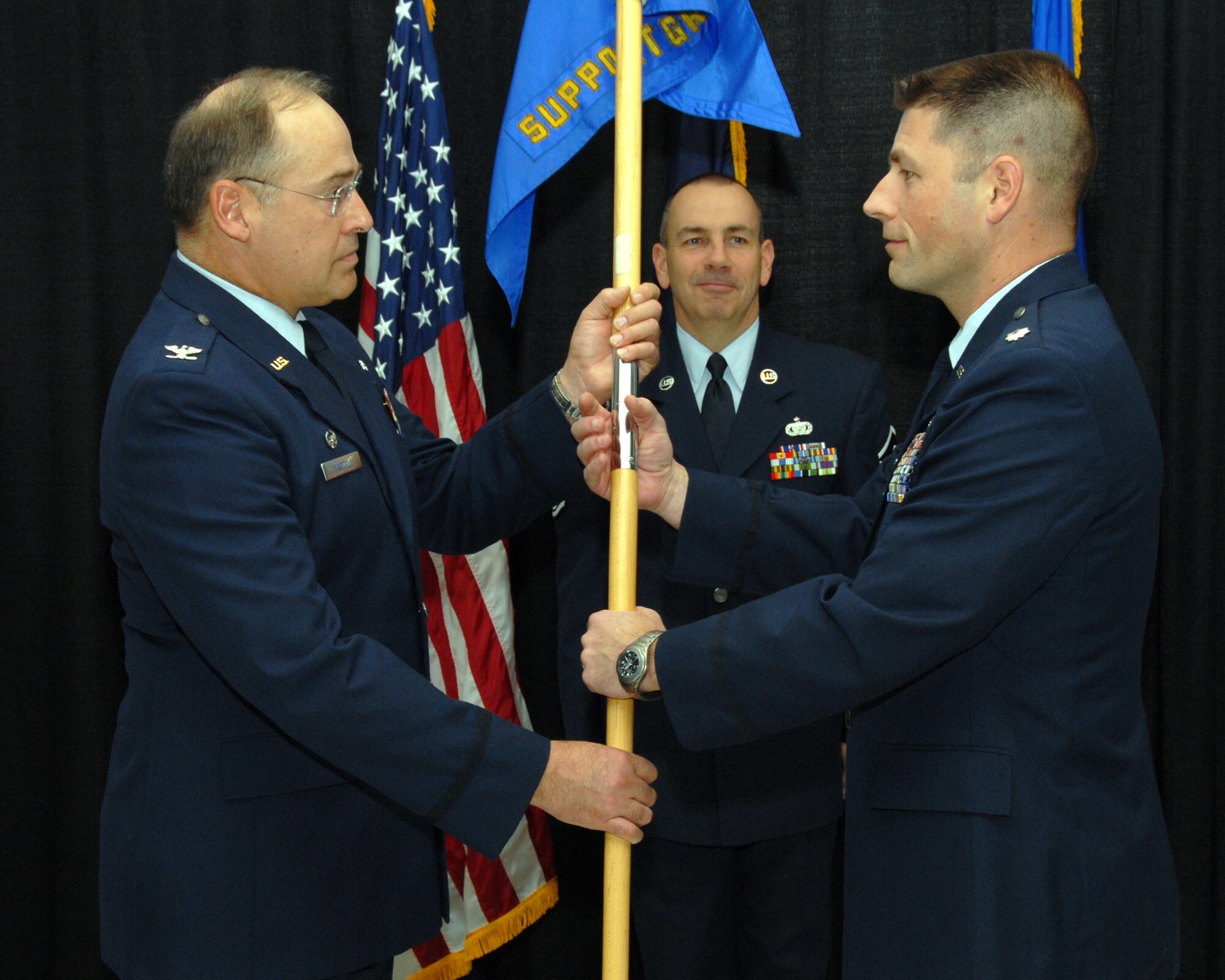Lieutenant Colonel Brian C. Elbert (right), accepts the 157th Mission Support Group guidon from Colonel Richard P. Martell, commander 157th Air Refueling Wing during the 157th MSG change of command at Pease Air National Guard Base, New Hampshire on November 8th, 2009.  Lt. Col. Elbert succeeds Colonel Leroy Dunkelberger as commander of the 157th MSG.  Master Sergeant Steve Shea, guidon bearer and 157th MSG first sergeant looks on.  (U.S. Air Force photo/Staff Sgt. Curtis J. Lenz)