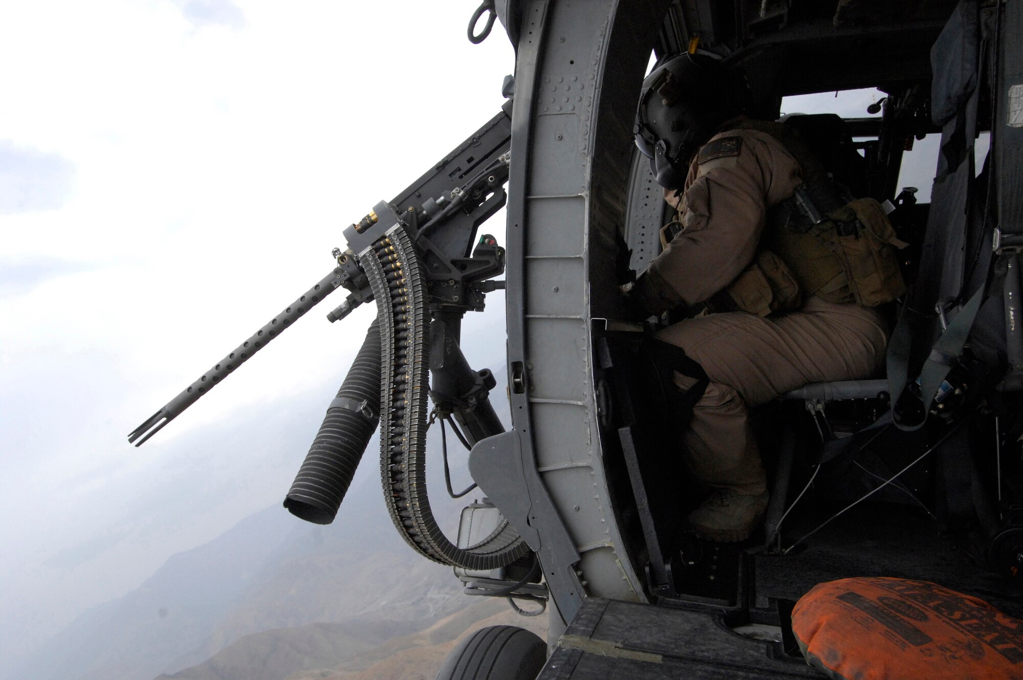 Staff Sgt. Justin Schramm, a flight engineer  on an HH-60G Pave Hawk scans the countryside while on a mission here. The Pave Hawks are used for Combat Search and Rescue, and have been operated by the U.S. Air Force since 1991. Sergeant Schramm is from Eugene, Ore., and is currently stationed at Kadena Air Base, Japan. Here Sergeant Schramm is working in the 33rd Expeditionary Rescue Squadron. (U.S. Air Force photo/Senior Airman Susan Tracy)