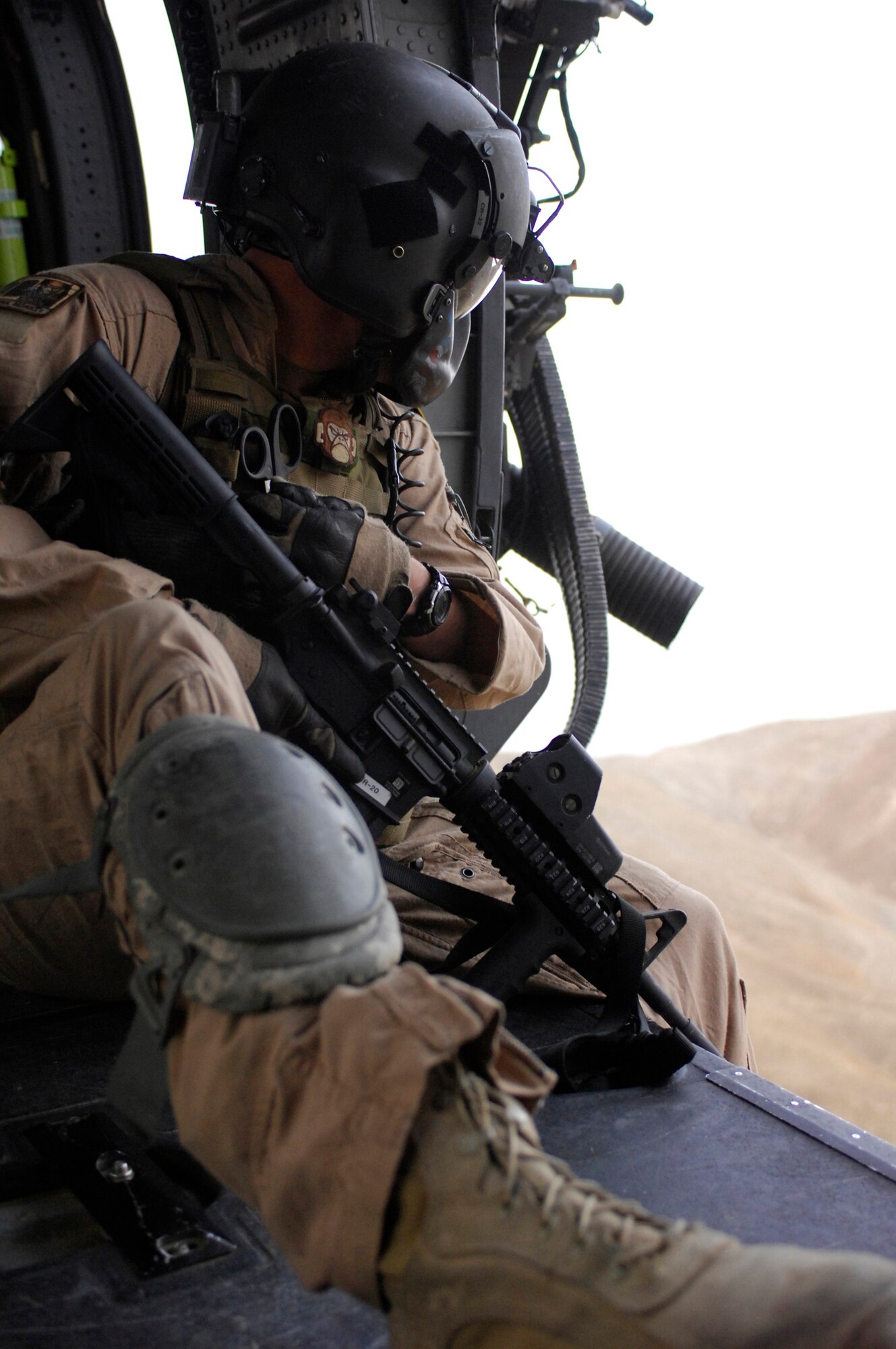 Senior Airman Michael Price, a flight engineer on an HH-60G Pave Hawk scans the countryside while on a mission here. The Pave Hawks are used for Combat Search and Rescue, and have been operated by the U.S. Air Force since 1991. Sergeant Schramm is from Tuscaloosa, Ala., and is currently stationed at Kadena Air Base, Japan. Here Sergeant Schramm is working in the 33rd Expeditionary Rescue Squadron. (U.S. Air Force photo/Senior Airman Susan Tracy)