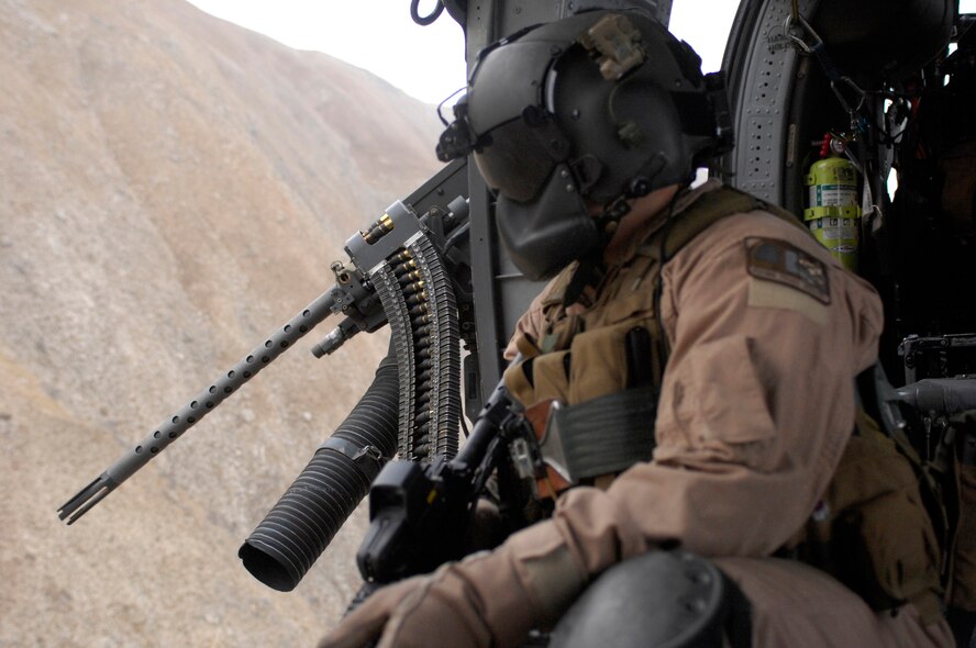 Staff Sgt. Justin Schramm, an aerial gunner  on an HH-60G Pave Hawk scans the countryside while on a mission here. The Pave Hawks are used for Combat Search and Rescue, and have been operated by the U.S. Air Force since 1991. Sergeant Schramm is from Eugene, Ore., and is currently stationed at Kadena Air Base, Japan. Here Sergeant Schramm is working in the 33rd  Expeditionary Rescue Squadron. (U.S. Air Force photo/Senior Airman Susan Tracy)