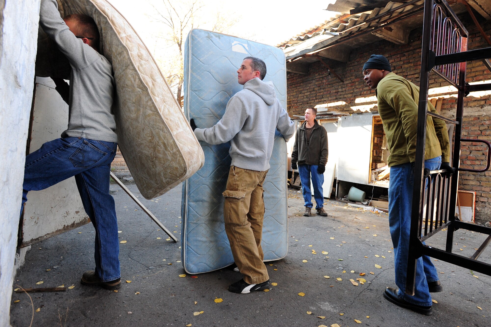 BISHKEK, Kyrgyzstan -- Airmen stand in a line with mattresses and bed frames to donate to the Bishkek Center for Mental Health. The Transit Center at Manas had an abundance of  bedding and shared the items with their host nation neighbors. (U.S. Air Force photo/Senior Airman Steele C. G. Britton)