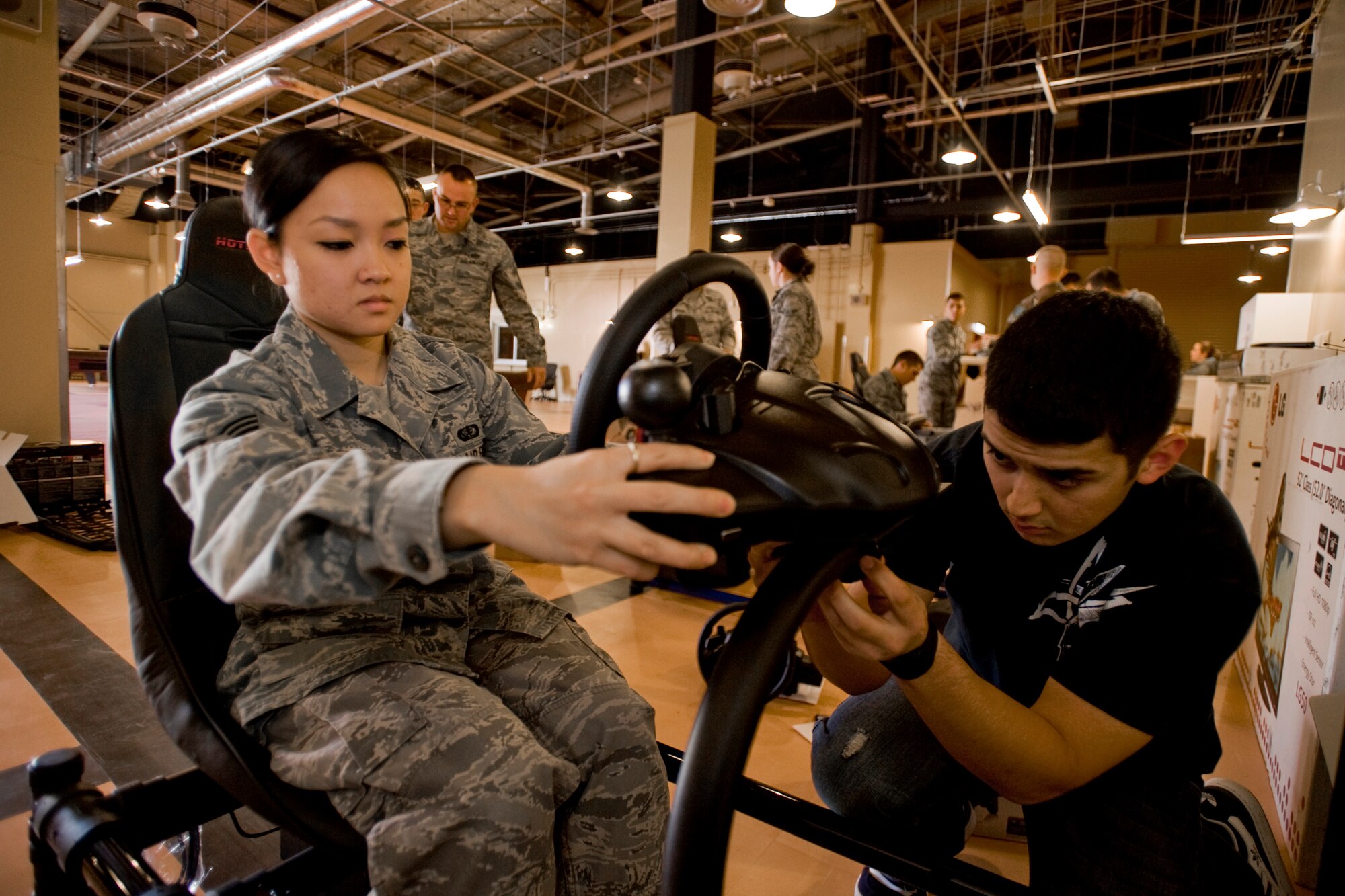 MISAWA AIR BASE, Japan -- Senior Airman Alicia Salviejo, 35th Force Support Squadron recreational specialist, and Airman Edgar Marquez, 35th FSS fitness specialist, assemble a driving simulator Nov. 6 at the Airman's Center. The new Airman's Center will be a place where E-4s and below can relax and hang out with friends. A grand opening is scheduled for Dec. 3. (U.S. Air Force photo/Senior Airman Jamal D. Sutter)