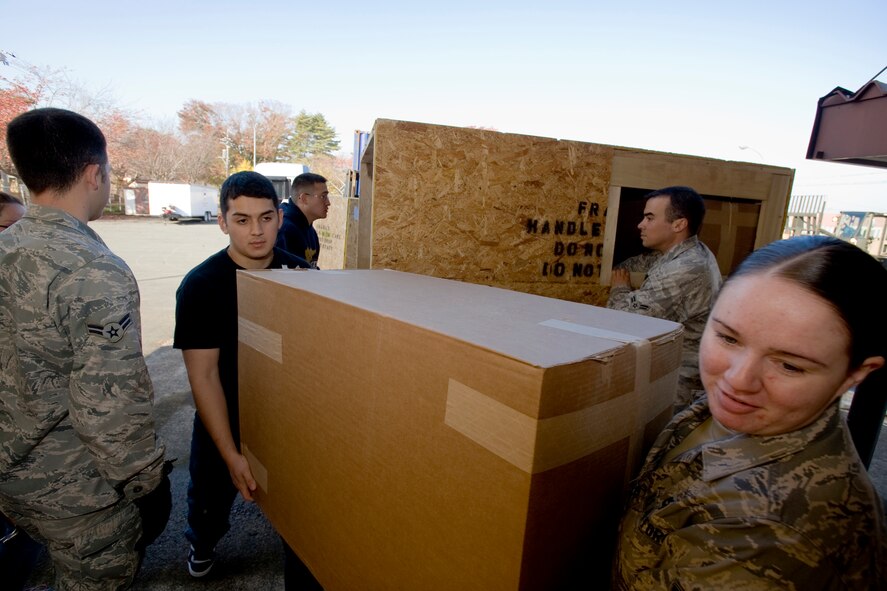 MISAWA AIR BASE, Japan -- Airman Nicole Mangione, 35th Maintenance Squadron non-destructive inspection journeyman, and Airman Edgar Marquez, 35th Force Support Squadron fitness specialist, help unload a shipment of furniture Nov. 6 in preparation for the new Airman's Center grand opening. More than 15 Airmen came out to help with the shipment, which weighed more than 65,000 pounds. (U.S. Air Force photo/Senior Airman Jamal D. Sutter)