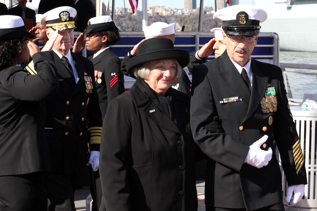 U.S. Navy Command Master Chief Robert W. Stocklin escorts Dotty England, wife of former Deputy Secretary of Defense Gordon England and the sponsor of amphibious transport dock USS New York, from the stage during the ship's commissioning ceremony in New York, Nov. 7, 2009. The ship has 7.5 tons of steel salvaged from the World Trade Center in its hull.