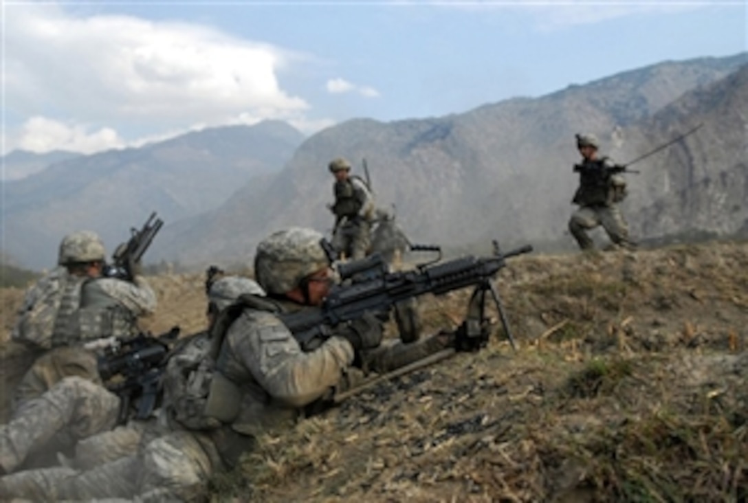 U.S. Army soldiers, from Charlie Company, 2nd Battalion, 12th Infantry Regiment, watch the surrounding hills for insurgents while fellow U.S. soldiers, of Charlie Company, race to their positions dodging heavy sniper fire during a three-hour gun battle with insurgent forces at Waterpur Valley, in Kunar province, Afghanistan, on Nov. 3, 2009.  