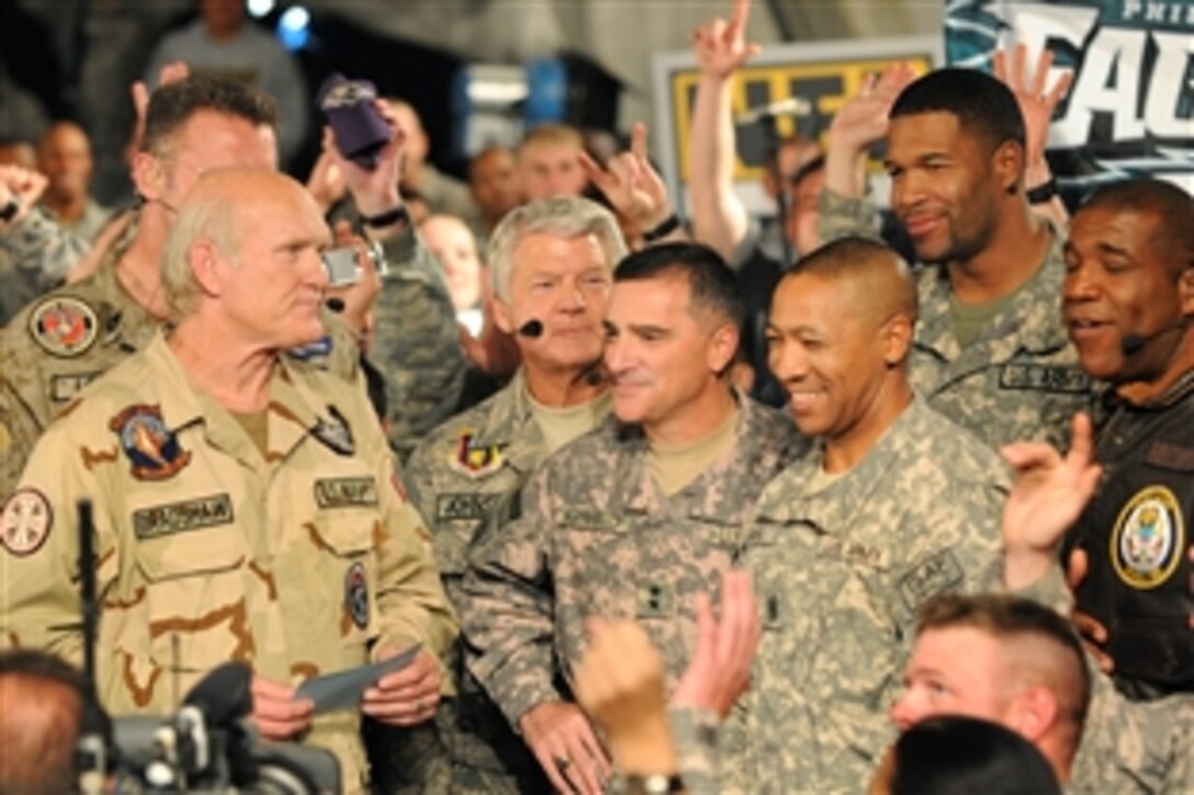 Fox Sports NFL Sunday commentators Terry Bradshaw, Howie Long, rear left, Jimmy Johnson, Michael Strahan, and Curt Menefee, talk with Maj. Gen. Curtis Scaparrotti, commanding general of Combined Joint Task Force- 82 and 82nd Airborne Division, and Command Sgt. Maj. Thomas Capel, command sergeant major of CJTF-82 and 82nd Abn. Div., during the filming of the NFL Sunday pre-game show at Bagram Airfield, Afghanistan, Nov. 7, 2009