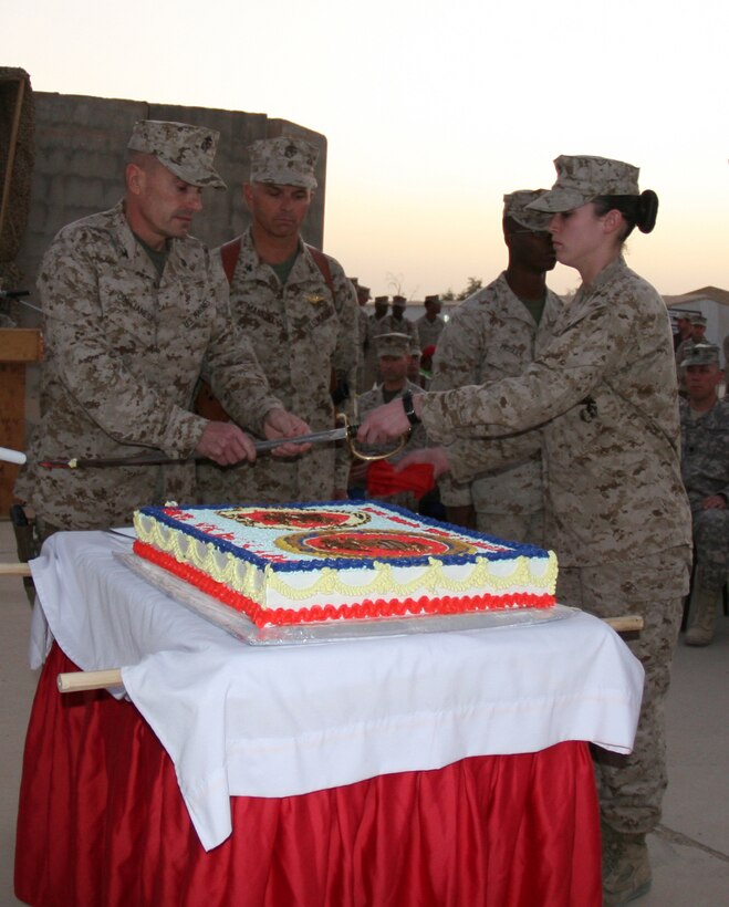 Col. Vincent A. Coglianese (left), the commanding officer of Combat Logistics Regiment 27 (Forward), passes the noncommissioned officer’s sword to Sgt. Katherine Meyer, the senior cake escort, after cutting the first piece of cake during the 234th Marine Corps birthday cake-cutting ceremony aboard Camp Al Taqaddum, Iraq, Nov. 10, 2009.  Following the ceremony, the Marines gathered to enjoy refreshments and camaraderie that Marines are known for.  (U.S. Marine Corps photograph by Lance Cpl. Melissa A. Latty)