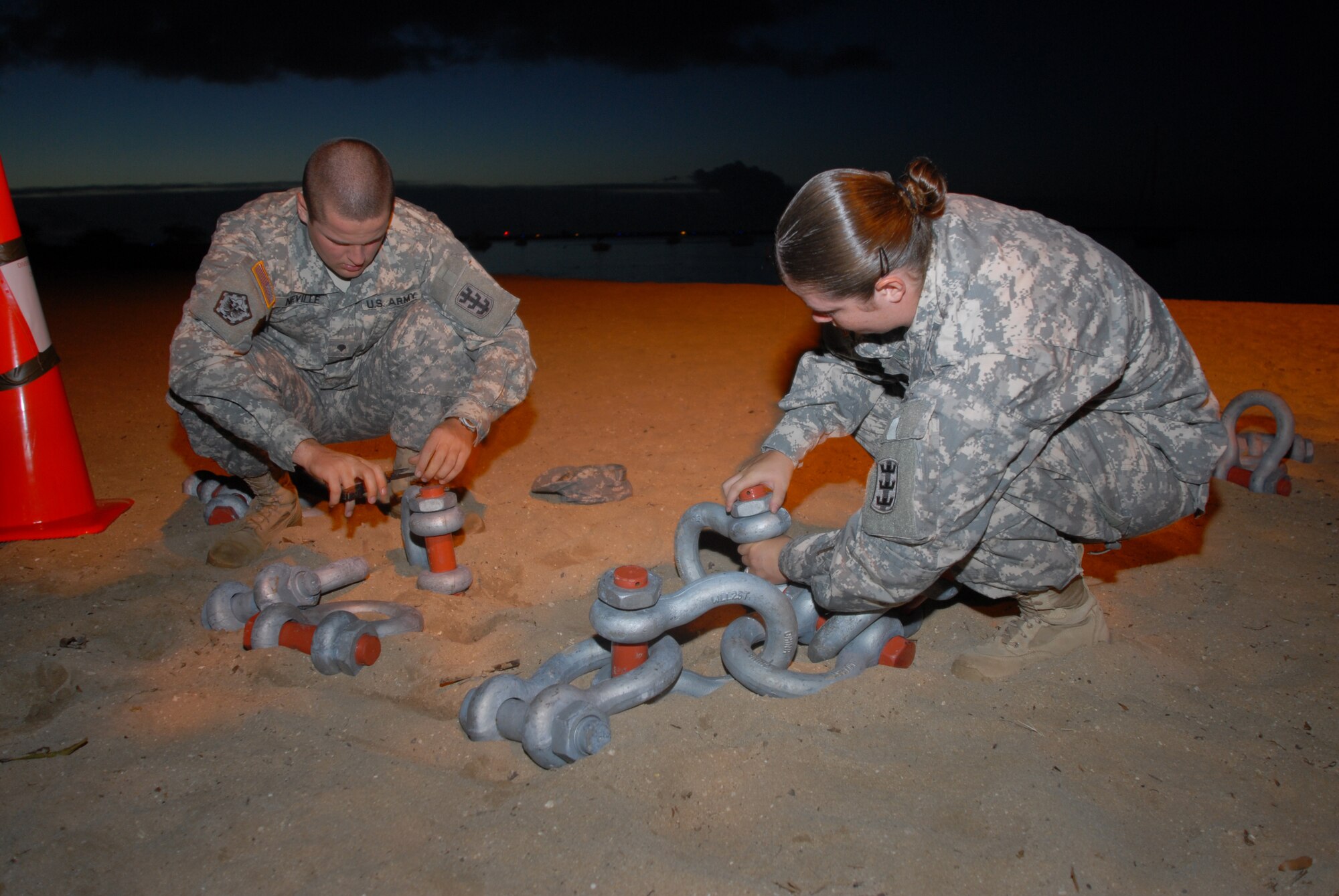 HICKAM AIR FORCE BASE, Hawaii -- Specialist Derrick Naville and Sergeant Angel Tizazu, 70th Engineer Company stationed out of Schofield Barracks, prep heavy chains for the start of the Divers Challenge here, Nov. 10. The event is held annually to challenge soldiers physically and mentally, build esprit de corps, and maintain traditions. (U.S. Air Force photo/Senior Airman Gustavo Gonzalez)