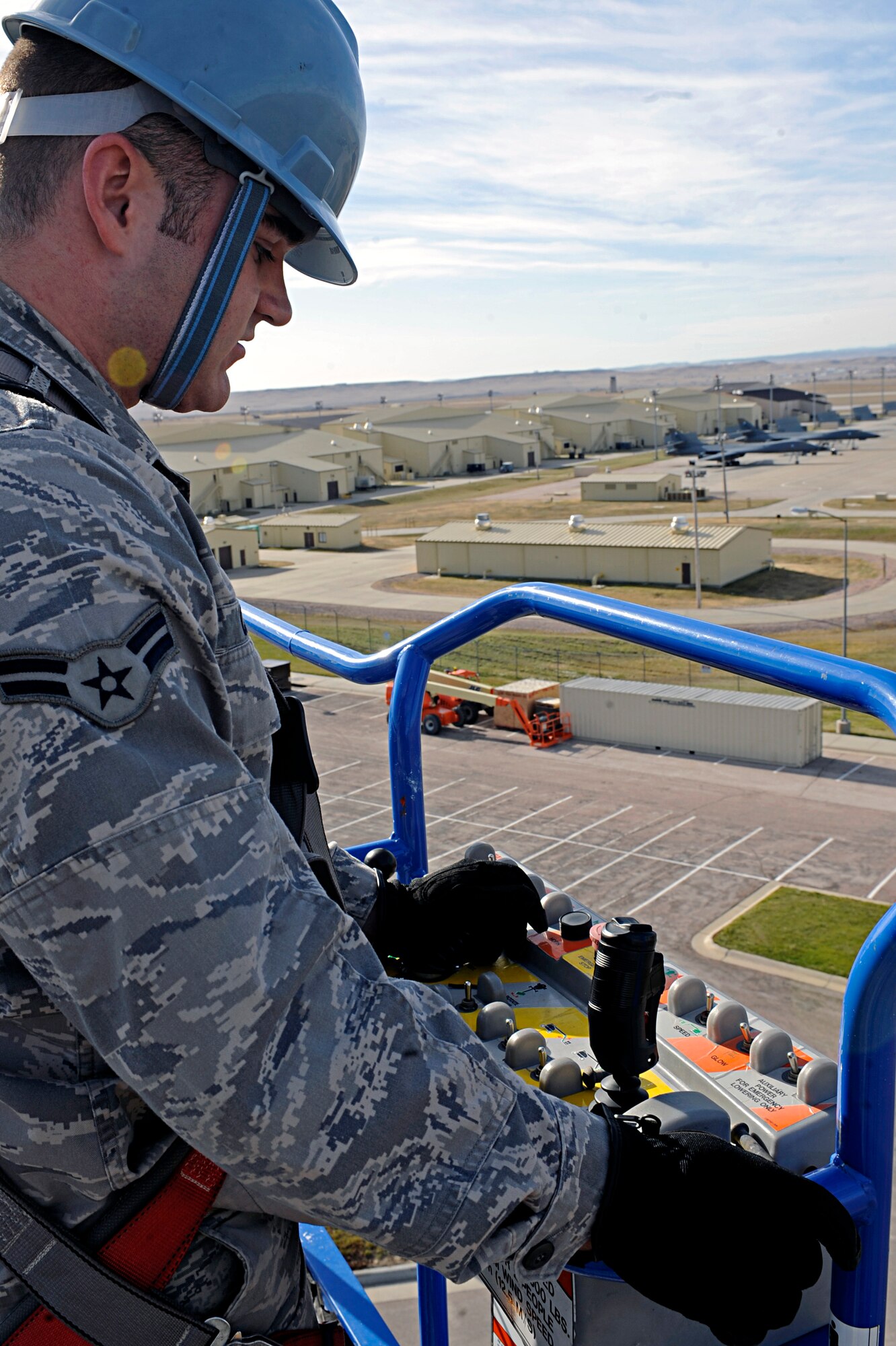 ELLSWORTH AIR FORCE BASE, S.D. -- Airman 1st Class Charles Canfield, 28th Communications Squadron ground radio technician, lowers a boom lift after replacing a speaker driver on one of the base speakers, Nov. 6. The speakers being repaired are one of many on base which plays taps, reveille, retreat and warnings. (U.S. Air Force photo/Airman 1st Class Matthew Flynn)