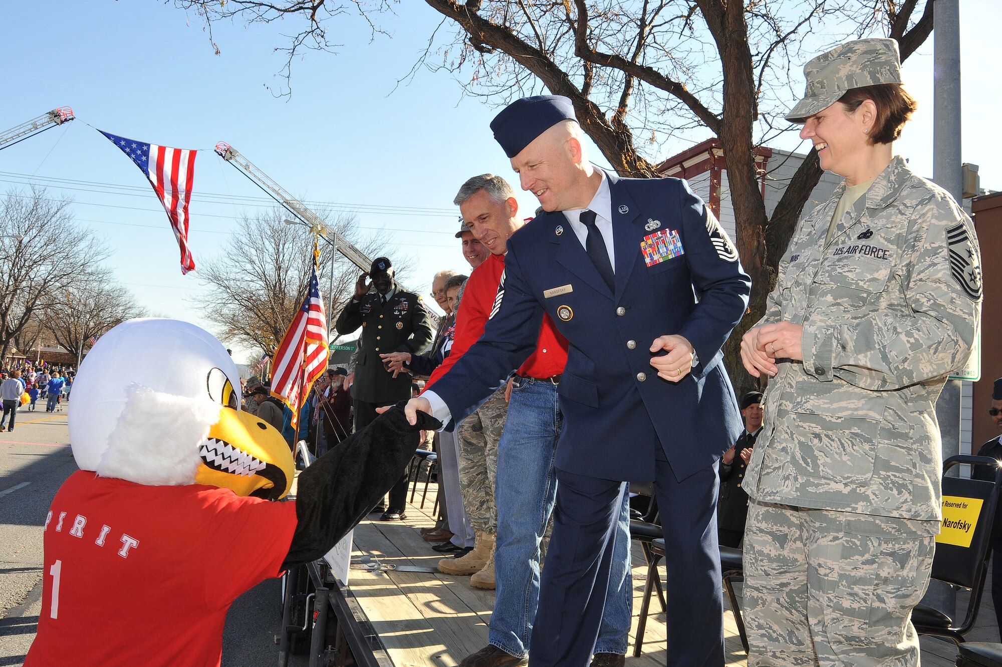 OFFUTT AIR FORCE BASE, Neb. - Chief Master Sgt. Thomas S. Narofsky, U.S. Strategic Command Chief, shakes hands from the review stand with a mascot during the Annual Official Nebraska Veterans Parade Nov. 7 in Olde Towne Bellevue, Neb., while 55th Wing Command Chief Master Sgt. Lisa A. Sirois looks on. The parade, in its 10th year, honors the service and sacrifices of all military veterans and their family members.  
U.S. Air Force photo by D.P. Heard
