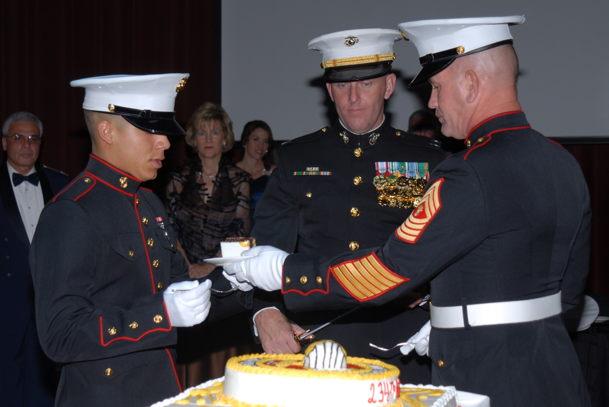 SAN ANGELO, Texas -- Marine Corps Master Gunnery Sgt. Peter Bordeleau, hands the second piece of cake to Marine Corps Pvt. A. H. Peralta at the 234th Marine Corps Birthday Ball hosted by the Marine Corps Detachment, Goodfellow Air Force Base, Nov. 7, 2009. The first piece of cake is given to the guest of honor, the second to the oldest Marine present. Upon receiving the second piece of cake, the oldest Marine will in turn pass it on to the youngest Marine present, signifying the passing of experience and knowledge from the old to the young of the Corps. (U.S. Air Force photo/Staff Sgt. Laura R. McFarlane)

