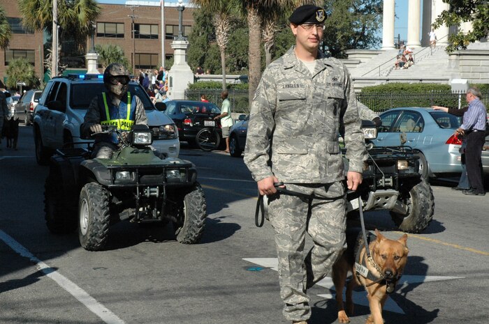 Staff Sgt. Justin Langley and his military working dog march in the Charleston Annual Tri-County Veteran's Day Parade Nov. 8 in downtown Charleston. This was the 12th Annual parade sponsored by the Ralph H. Johnson VA Medical Center. Sergeant Langley is a military working dog handler with the 437th Security Forces Squadron. (U.S. Air Force photo/Senior Airman Dani Shea)

