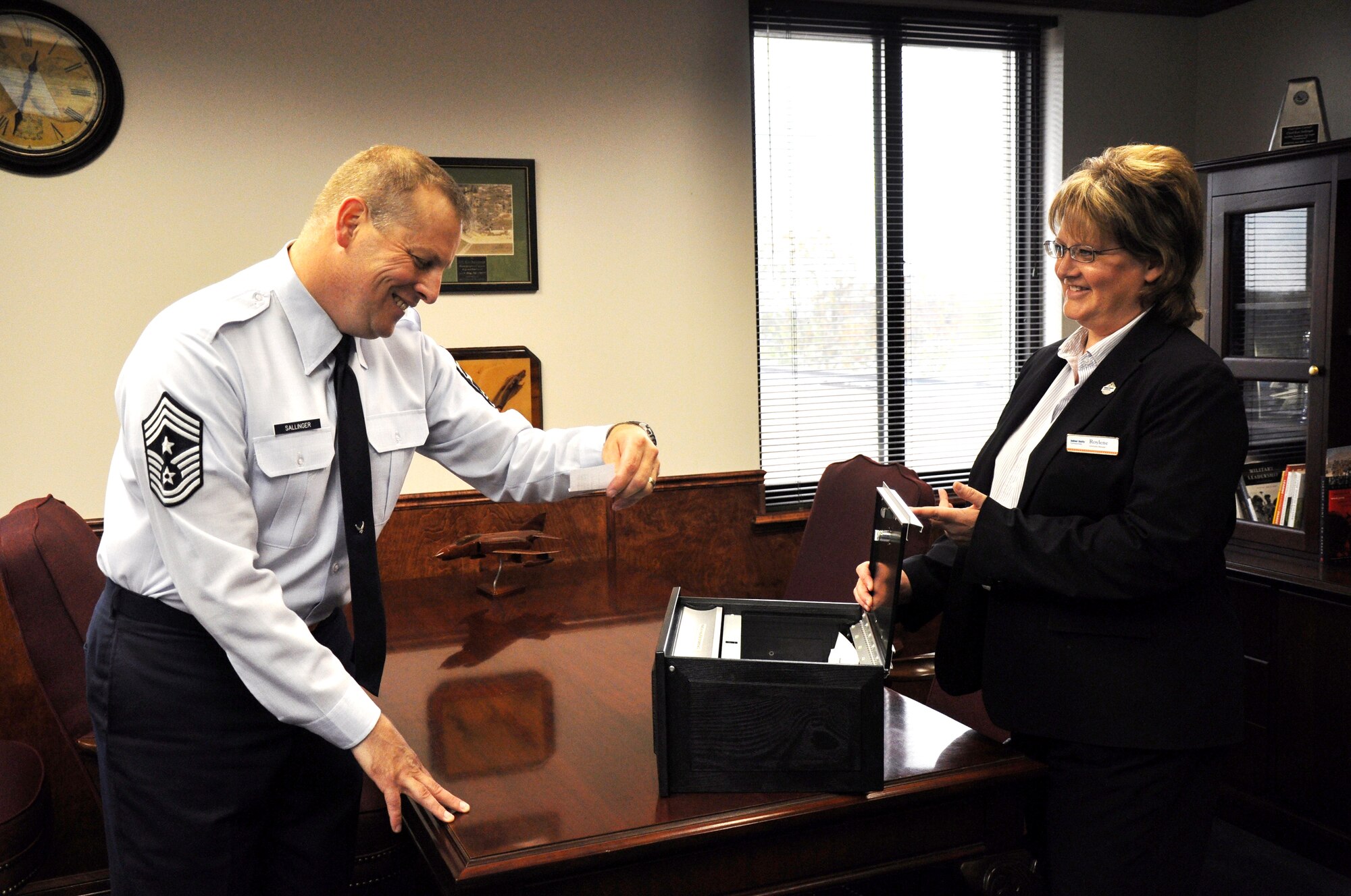 Chief Master Sgt. Kenneth Sallinger, 82nd Training Wing command chief, and Roylene Quintero, a community manager for Balfour Beatty Communities, draw a name from the box of participants for the Annual CEL Housing Survey Nov.9. The survey participants were eligible to win one of two gift cards in the amounts of $1,000 and $500. (U.S. Air Force photo/ Airman 1st Class Adawn Kelsey)