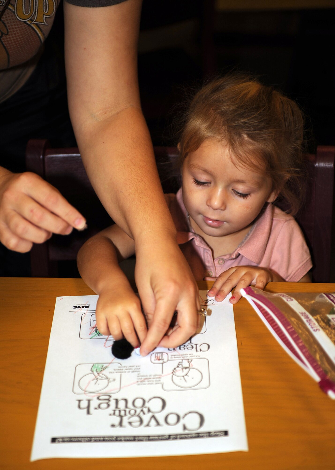 Rochelle Edwards, age 2, puts simulated germs onto her "Cover Your Cough" coloring sheet at the Watkins-Das Library on Seymour Johnson Air Force Base, N.C., Nov. 10, 2009. The children in attendance were taught basic hygiene and how to eliminate spreading germs when coughing or sneezing. Rochelle is the daughter of daughter of Joy and Tech. Sgt. Johnny Edwards, 333rd Fighter Squadron. (U.S. Air Force photo/Senior Airman Ciara Wymbs)