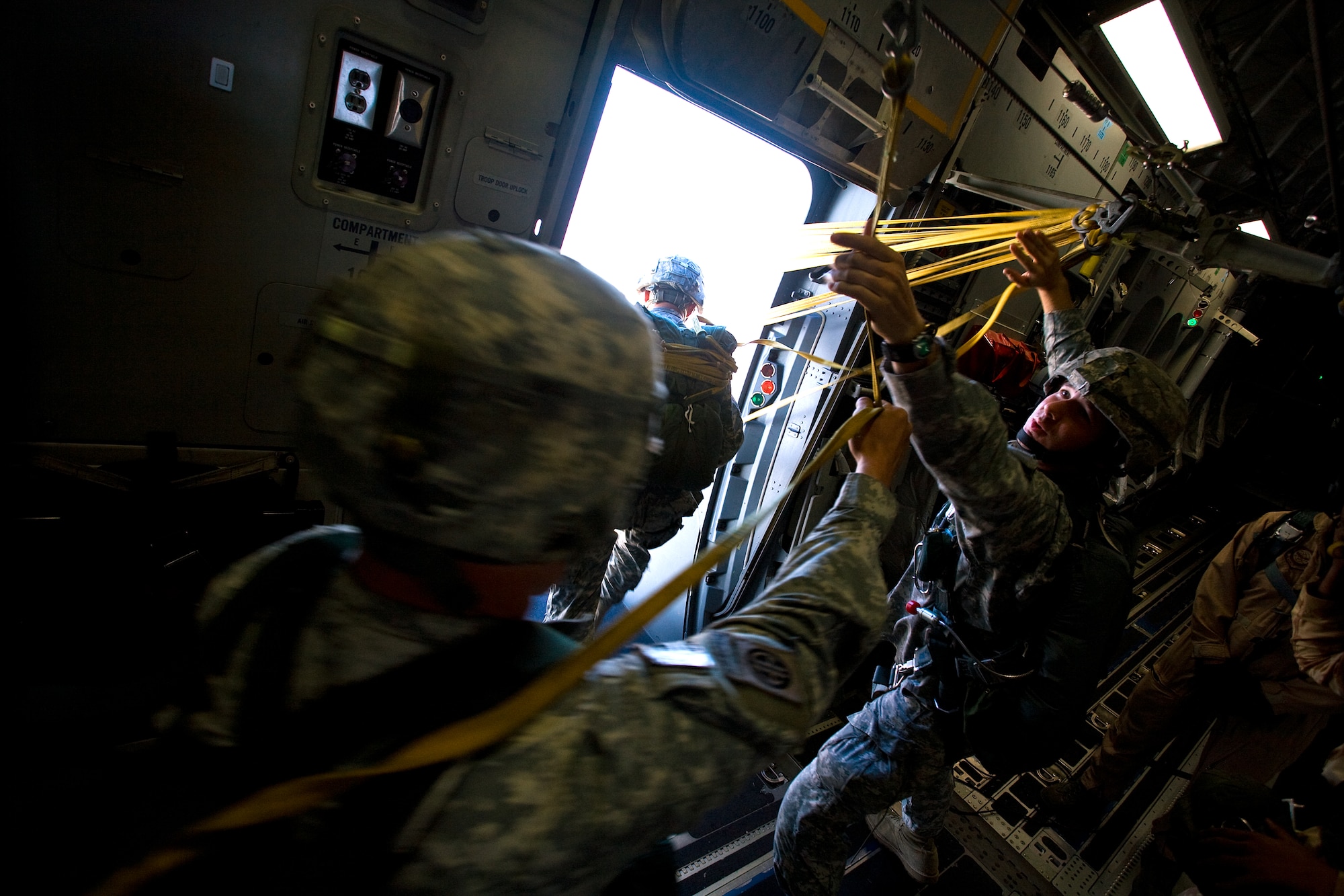 Army Sgt. Erik Gimm catches soldiers static lines a they exit a C-17 over a drop zone west of Cairo, Egypt Oct. 15. Sergeant Grimm is assigned to the Army's 82nd Airborne Division, 2nd Brigade Combat Team from Ft. Bragg, N.C. (U.S. Air Force photo/Col. Joseph Mancy)