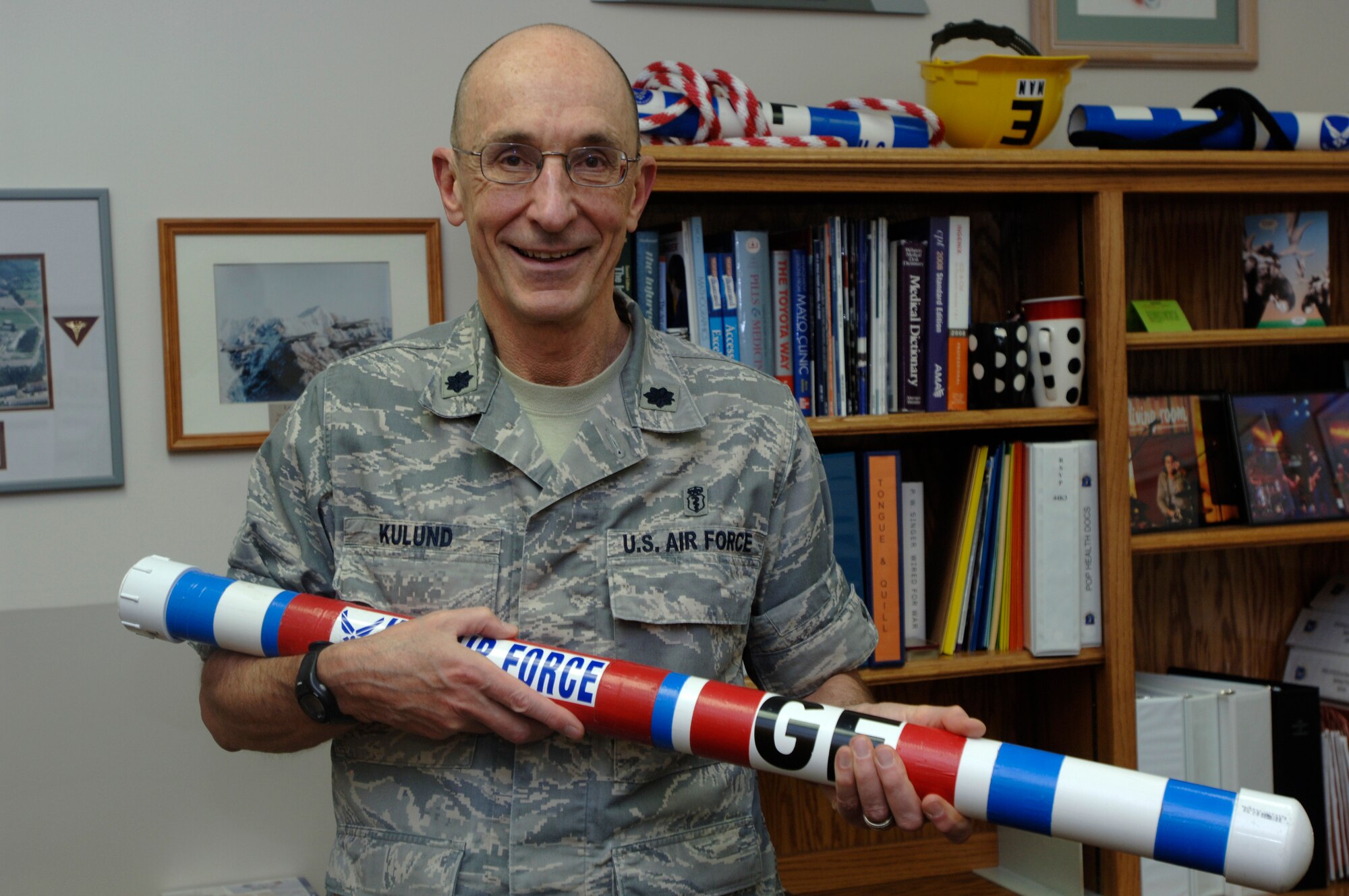 Lt. Col. Daniel N. Kulund, 319th Medical Group, shows off the “fighting stick” he developed. Colonel Kulund came up with the idea after seeing Airmen have trouble handling and lifting an M-16. The stick is a 40 inch long, 10 pound plastic pipe filled with sand. Colonel Kulund has also developed 15 exercises and defensive fighting drills to be used with the stick; this program has become an exercise staple at Grand Forks Air Force Base. (U.S. Air Force photo by 2nd Lt. Anastasia Wasem)