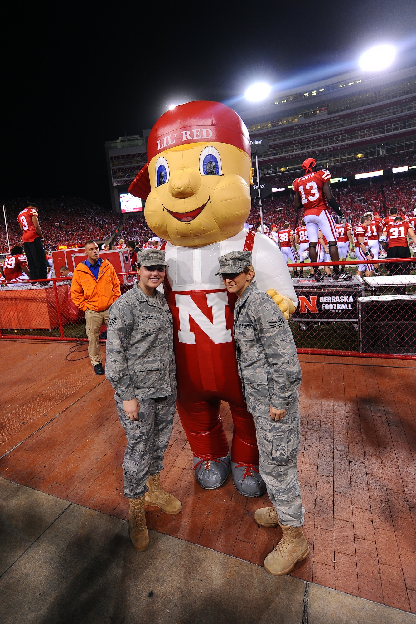 OFFUTT AIR FORCE BASE, Neb. - Senior Airmen Antonia Cefalu and Sara Lasley, both assigned to U. S. Strategic Command, pose with University of Nebraska mascot Lil Red at the military recognition football game against Oklahoma University held at Memorial Stadium, Lincoln, Neb., Nov. 7.  U.S. Air Force photo by Josh Plueger

