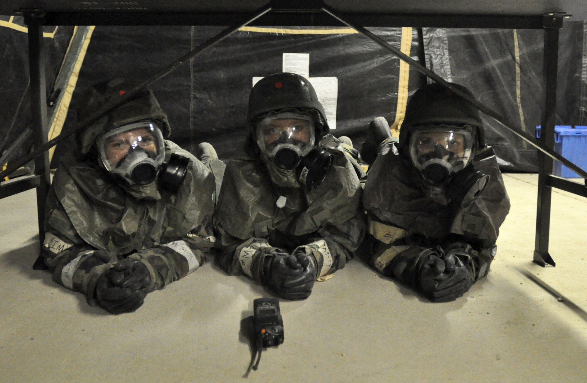 Staff Sgt. Crystal Thompson, Tech. Sgt. Afton Meeks, and Senior Airman Anna Steinfeldt of the 419th Medical Squadron take shelter under a table during a simulated attack. (U.S. Air Force photo/ Staff Sgt. Kyle Brasier)