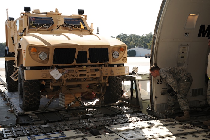 Senior Airman Joshua Humble ensures clearance as a mine-resistant, ambush-protected all-terrain vehicle is loaded from a Tunner 60K Loader onto a Boeing 747-400 aircraft here Nov. 7. Airmen with the 437th Aerial Port Squadron loaded five M-ATVs through the side of the aircraft with two inches of clearance to spare. Airman Humble is an air transportation specialist with the 437 APS Ramp Services. (U.S. Air Force photo/Staff Sgt. Marie Brown)(RELEASED)