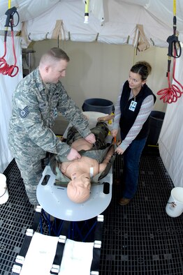 MINOT AIR FORCE BASE, N.D. -- Tech. Sgt. Keith Lewis, 5th Medical Operations Squadron aerospace and operational physiology noncommissioned officer-in-charge, assists Callie Auguston, 5th Medical Support Squadron medical readiness planner and analyst, as they practice patient decontamination to ensure they are ready to ensure Minot Airmen are safe Nov. 5 here. The medical readiness flight ensures 5th Medical Group Airmen are ready to deploy in support of their countries interests around the world. The 5th MDG recently underwent a Health Services Inspection that covered 16 areas in four major categories. The group received an overall rating of excellent with eight of the graded areas receiving an outstanding, the highest rating possible. (U.S. Air Force photo by Airman 1st Class Benjamin Stratton)