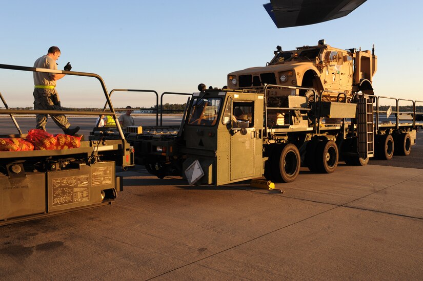 Staff Sgt. Gregory May guides a Tunner 60K Loader to the back of another to transfer the fourth of five mine-resistant, ambush-protected all-terrain vehicles to a Boeing 747-400 aircraft here Nov. 7. The Airmen loading the vehicles utilized two 60K loading vehicles together to expedite the loading process. Sergeant May is an air transportation specialist with the 437th Aerial Port Squadron Ramp Services. (U.S. Air Force photo/Staff Sgt. Marie Brown)
