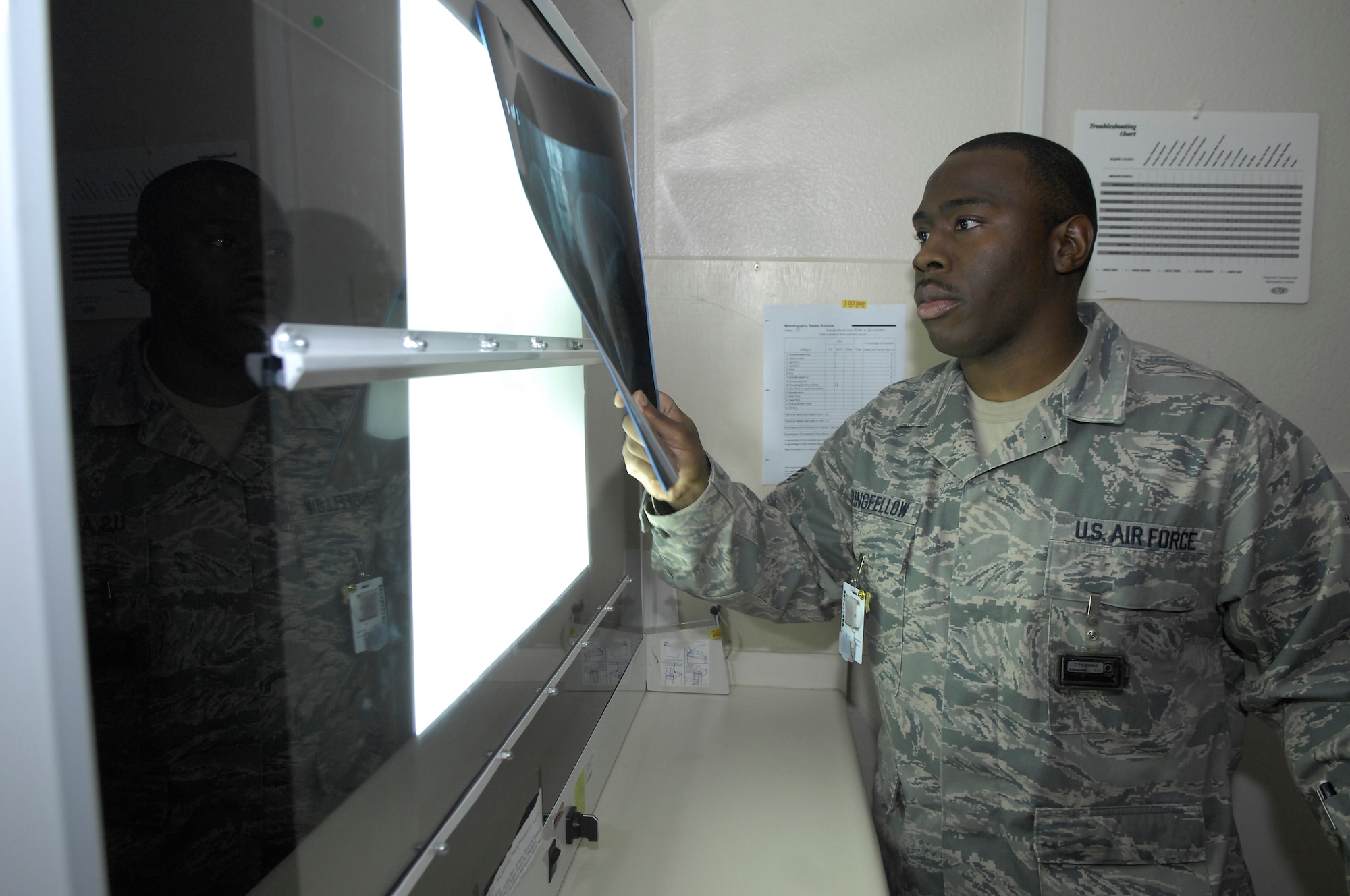 MINOT AIR FORCE BASE, N.D. -- Senior Airman Job Stringfellow, 5th Medical Operations Squadron diagnostic imaging technician, reviews x-rays using a light box here Nov. 9. The 5th Medical Group is meeting the challenge of safe effective delivery of healthcare coupled with significant deployment and heavy readiness exercise obligations.  The medical group was rated outstanding in eight of the 16 major graded areas during the Air Force Inspection Agency Health Services Inspection and captured an overall excellent rating.  (U.S. Air Force photo by Senior Airman Sharida Jackson)