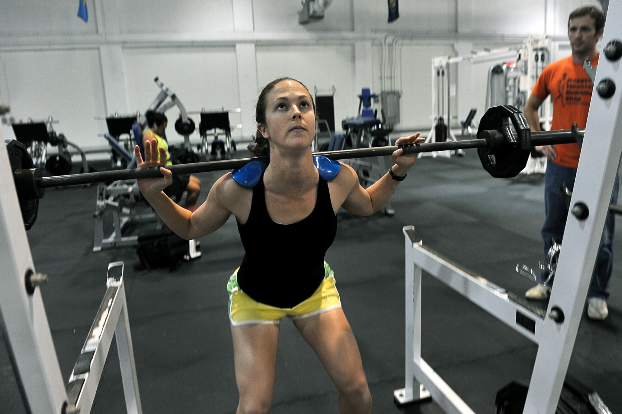 OFFUTT AIR FORCE BASE, Neb. -- Second Lt. Lindsey Myhr, 55th Maintenance Squadron accessory flight commander, does squats while her husband Sean Myhr coaches her inside the Offutt Field House Nov. 5 in preparation for her next triathlon.  A basic triathlon event consists of a 1.5-km swim, a 40-km bike ride, and a 10-km run. The biggest triathlon event, the Iron Man challenge, consists of a 2.4 mile swim, 112 miles on bike and a 26.2 mile run.

U.S. Air Foce photo by Charles Haymond