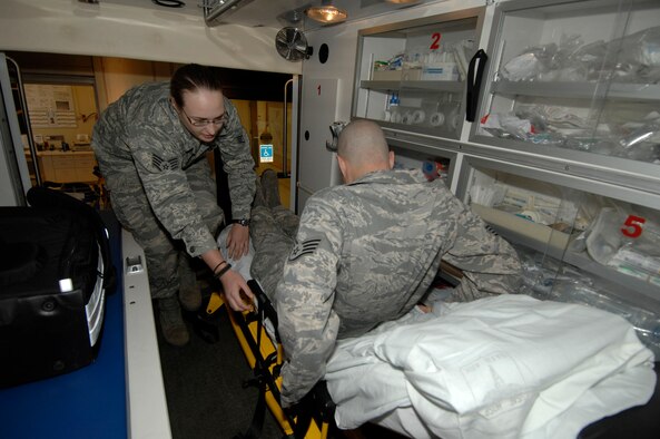 MINOT AIR FORCE BASE, N.D. -- Staff Sgt. Amber Schumacher and Staff Sgt. Jason Slajchert, aerospace medical technicians from the 5th Medical Operations Squadron prepare to perform gurney training here Nov 9. The 5th Medical Group is meeting the challenge of safe effective delivery of healthcare coupled with significant deployment and heavy readiness exercise obligations. The medical group was rated outstanding in eight of the 16 major graded areas during the Air Force Inspection Agency Health Services Inspection and captured an overall excellent rating. (U.S. Air Force photo by Senior Airman Matthew Smith) 
