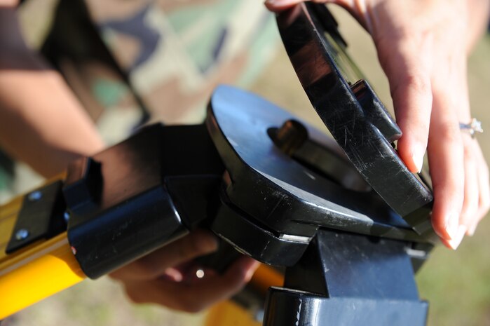Airman 1st Class Nicole Reynolds sets up a tripod for an Auto-Level measurement tool in Hunley Park family housing here during  training on performing site surveys Nov. 4. The site development shop performs surveys on fire hydrants and drainage systems for accurate base information on their location. Airman Reynolds is an engineering assistant with the 437th Civil Engineer Squadron Site Development Shop. (U.S. Air Force photo/Senior Airman Katie Gieratz)