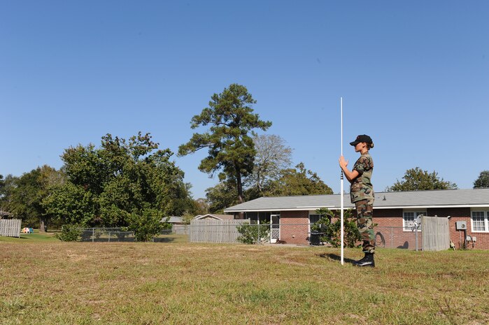 Airman 1st Class Nicole Reynolds adjusts a Philadelphia Rod in Hunley Park family housing here for training on performing site surveys Nov. 4. The Philadelphia Rod is used to provide a line of sight in conjunction with the Auto-Level at a set location to determine the elevation levels for future building sites. Airman Reynolds is an engineering assistant with the 437th Civil Engineer Squadron Site Development Shop. (U.S. Air Force photo/Senior Airman Katie Gieratz)