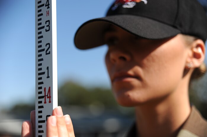 Airman 1st Class Nicole Reynolds adjusts a Philadelphia Rod in Hunley Park family housing here for training on performing site surveys Nov. 4. The Philadelphia Rod is used to provide a line of sight in conjunction with the Auto-Level at a set location to determine the elevation levels for future building sites. Airman Reynolds is an engineering assistant with the 437th Civil Engineer Squadron Site Development Shop. (U.S. Air Force photo/Senior Airman Katie Gieratz)