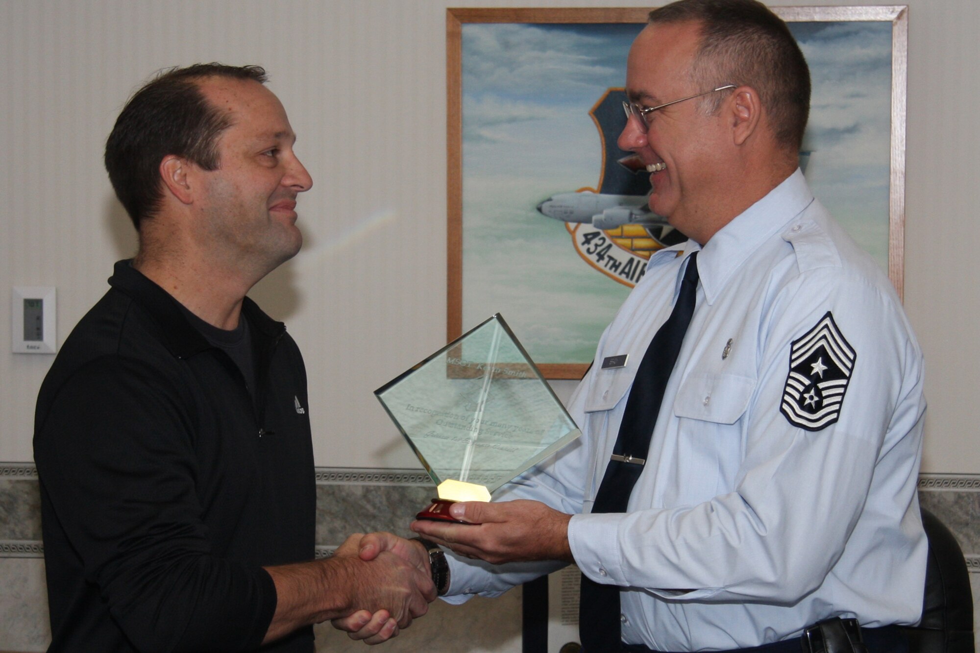GRISSOM AIR RESERVE BASE, Ind., -- Chief Master Sgt. Larry Brady, 434th Air Refueling Wing command chief, presents a plaque to recently retired Master Sgt. Kevin Smith, 434th Mission Support Squadron, for his service as the unit's first sergeant. (U.S. Air Force photo/Staff Sgt. Mark Orders-Woempner)